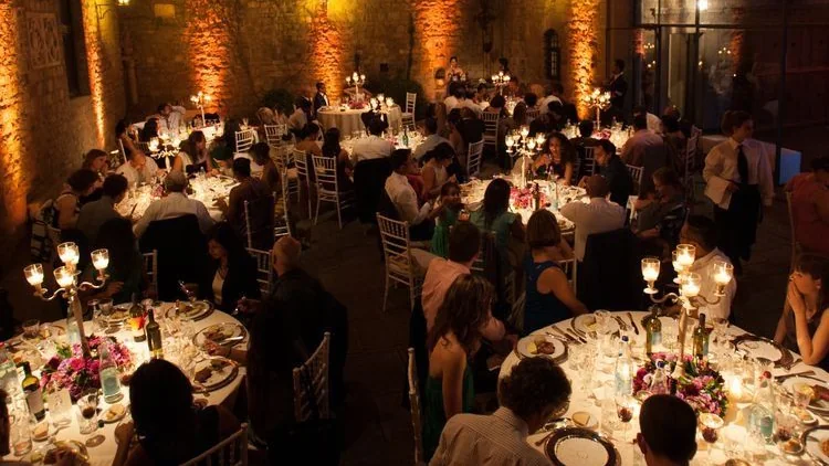 Dîner de nombreuses tables dans la cour illuminée d’un château