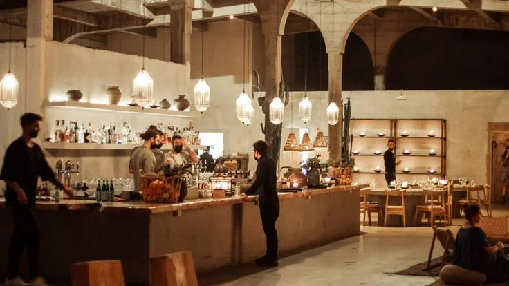Équipe au travail derrière le comptoir d’un grand restaurant sous des arches