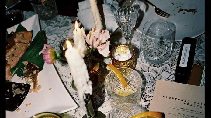 Table dressée avec nappe en dentelle, bougies et verres en cristal, sans convives
