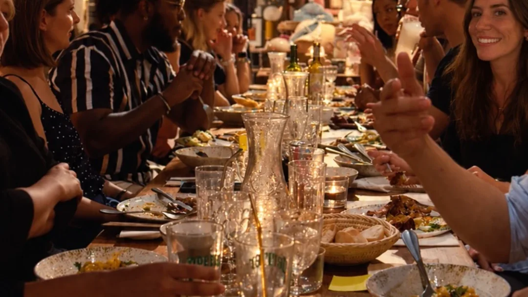 Entrepreneurs en conversation autour d’une longue tablée dans un restaurant